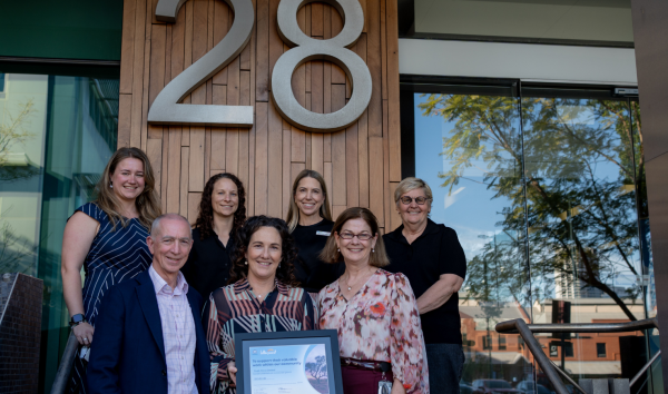 Lotterywest grant to transform Perth's first Youth Mental Health Hub 2 Group of people holding a certificate in a frame in front of a building number 28